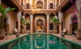 A stunning view of a luxury Marrakech riad courtyard with an emerald pool, a key consideration for where to stay in Marrakech for an authentic stay.