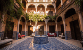 Affordable riad courtyard in Marrakech with traditional fountain and Moroccan architecture at sunset