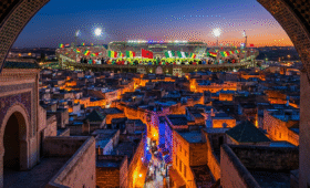 Exciting Fes AFCON 2025 banner showing historic medina and Stade de Fès stadium alive with fans, perfect for Morocco football tournament travel inspiration in vibrant Fes cityscape