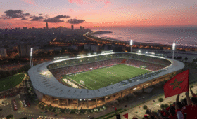 Exciting aerial view of Stade Mohammed V in Casablanca AFCON 2025, crowds cheering under stadium lights with Moroccan flags, perfect for football fans planning their trip to Morocco's vibrant host city.