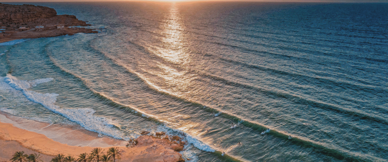 Morocco beach itinerary 7 days coastal adventure aerial sunset view of Taghazout Bay surfers and golden sand