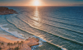 Morocco beach itinerary 7 days coastal adventure aerial sunset view of Taghazout Bay surfers and golden sand