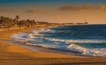 Panoramic view of Ain Diab urban beach along Casablanca Morocco coastline at golden hour, with Atlantic waves and city skyline, showcasing the best Casablanca Morocco beach experience