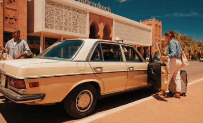 A classic beige Mercedes taxi waiting outside Marrakech Menara Airport terminal for arriving passengers.