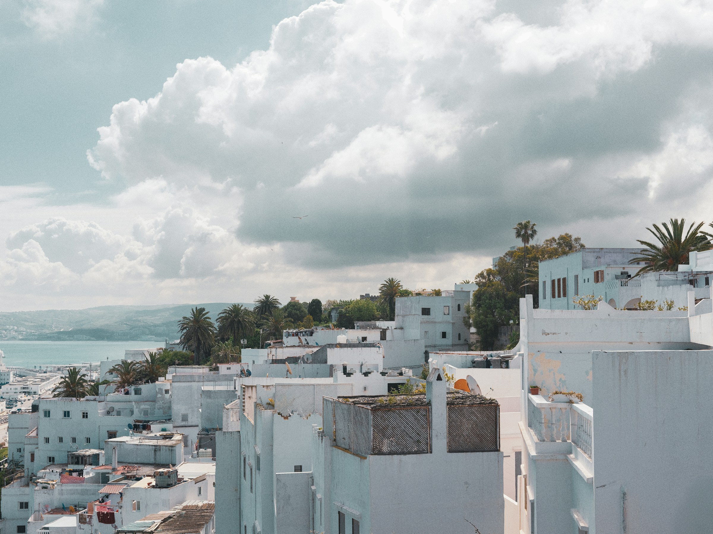 white medina rooftops in tangier morocco with the strait of gibraltar in the background