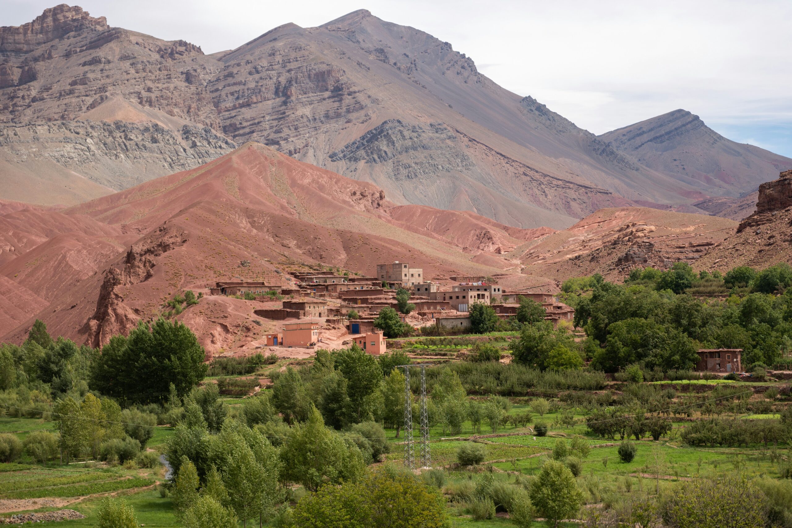A picturesque scene of a small village nestled in a valley, surrounded by mountains, Ouarzazate