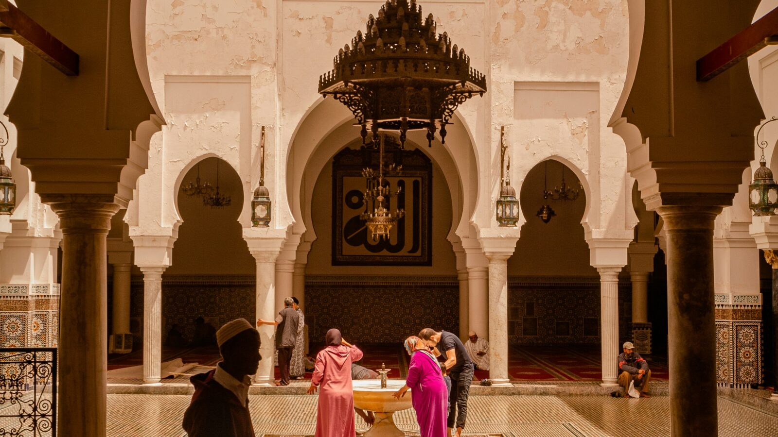 A group of people gathered in a courtyard with a dome ceiling, Fes