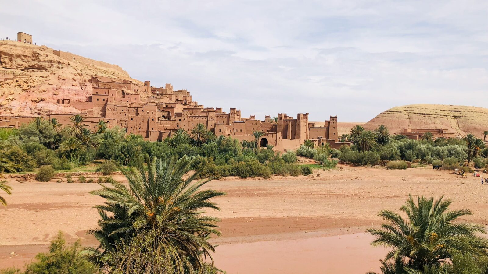 A picturesque scene of a desert landscape with a small village in the background, Guelmim