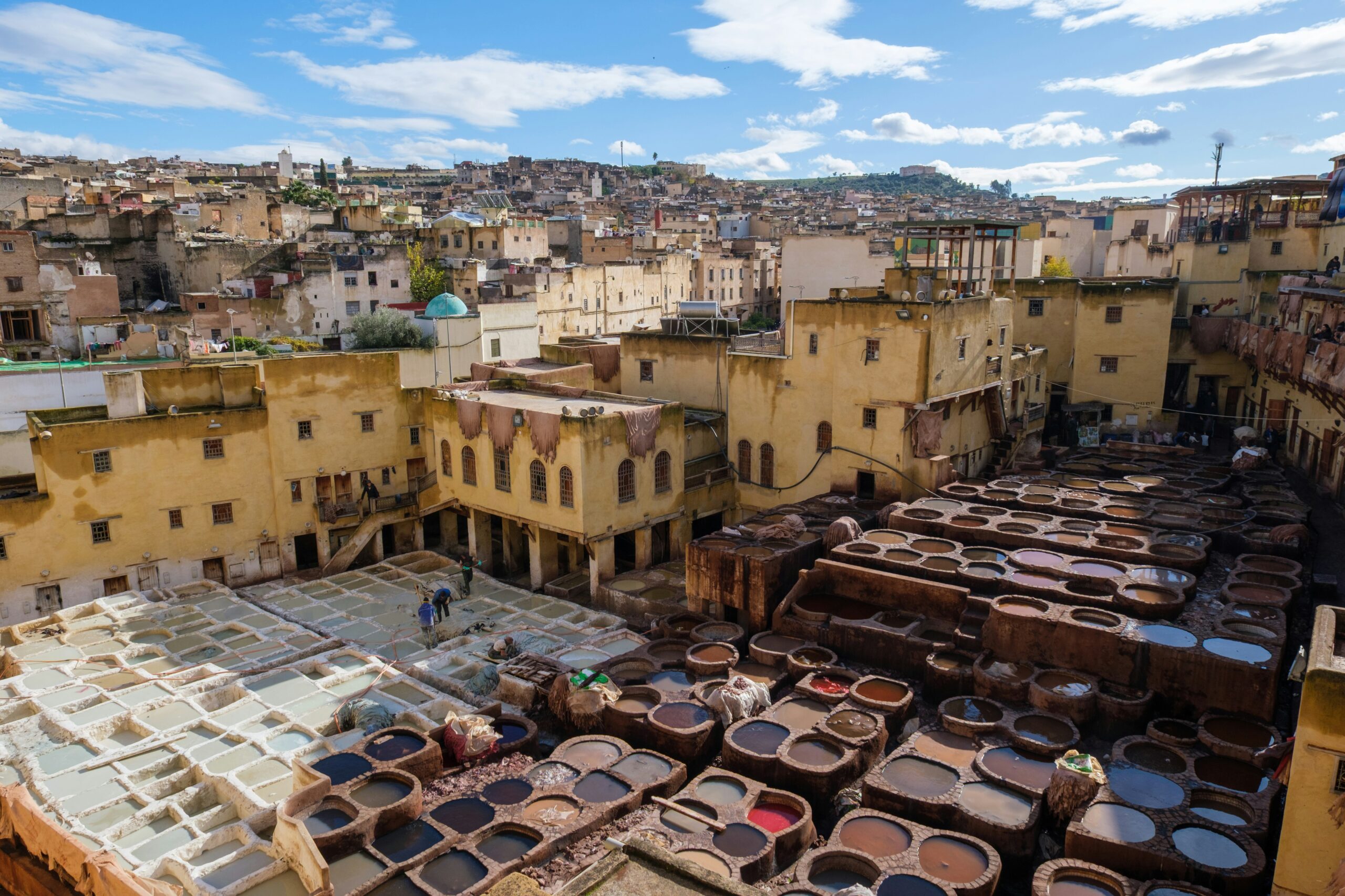 Chouara Tannery in Fes medina with workers dyeing leather in traditional stone vats