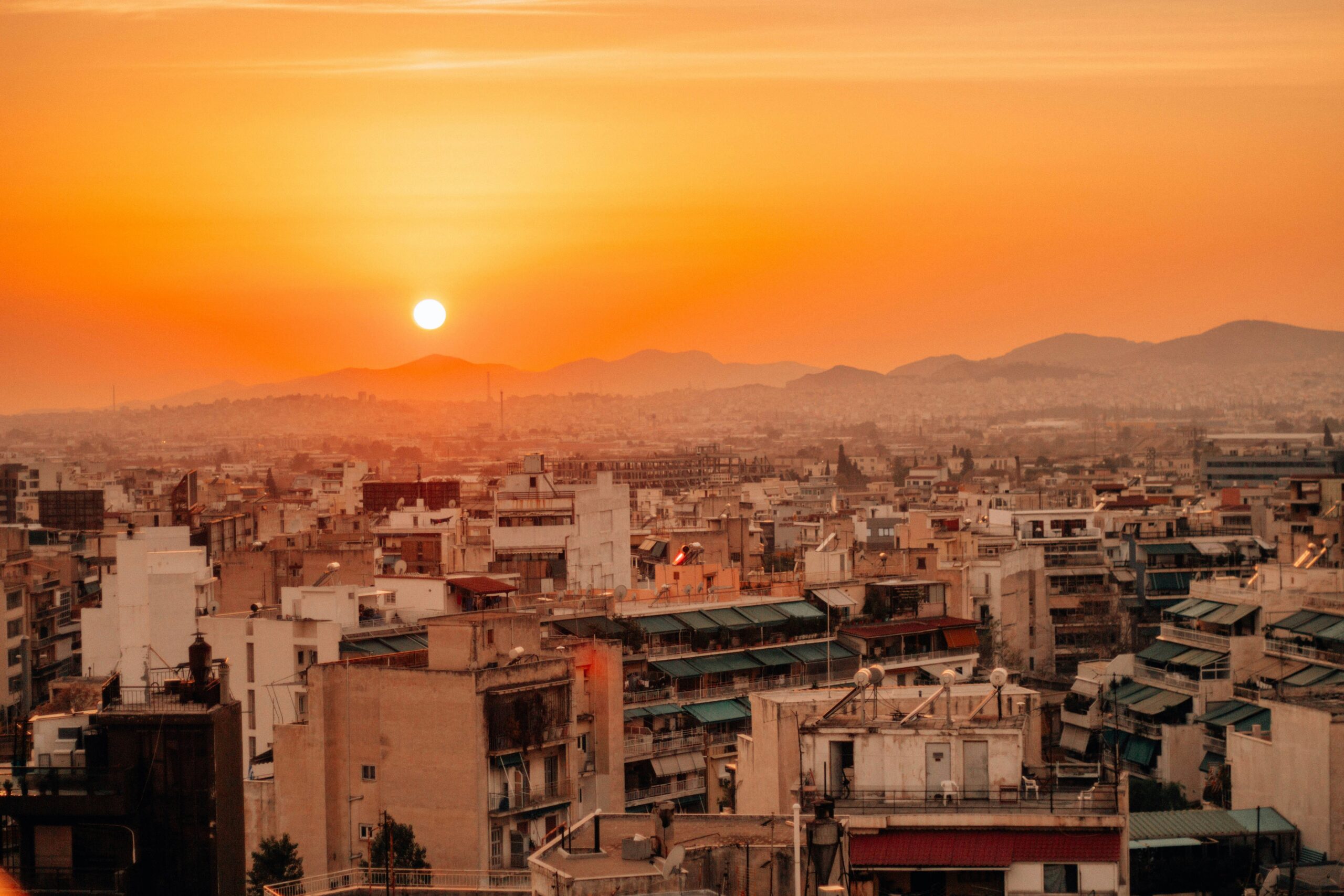 Rooftop view over Fes medina at sunset with minarets and Atlas Mountains in distance